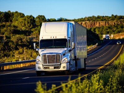 A modern freight truck being loaded with construction materials